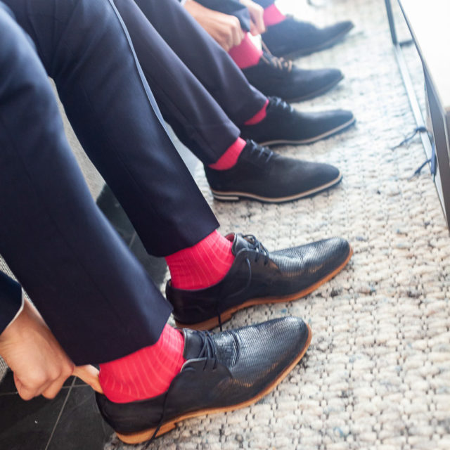 Bruidsfotografie; trouwfotograaf; De bruidegom, zijn schoonvader en zijn drie zonen dragen allemaal dezelfde kleur sokken, fuchsia roze.