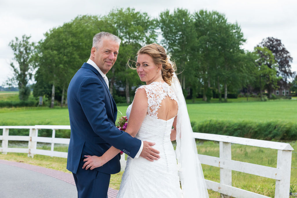 Bruidsfotografie; trouwfotograaf; Verliefde blikken tussen de bruid en de bruidegom tijdens het maken van de trouwreportage in Aduarderzijl