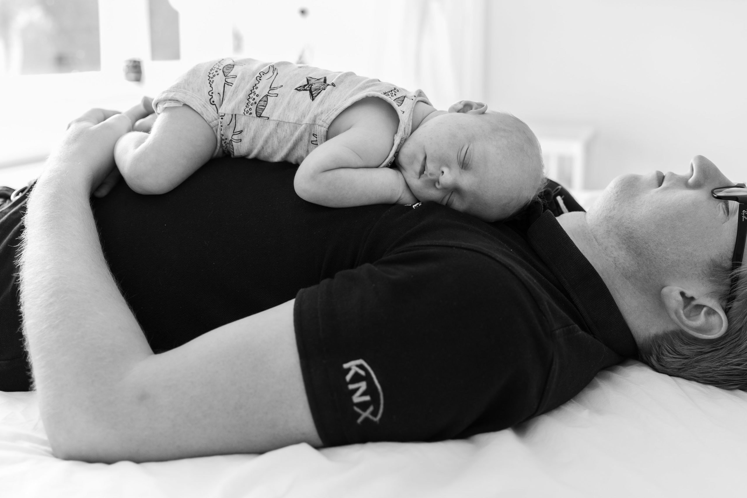 Newborn fotografie; baby slaapt op papa