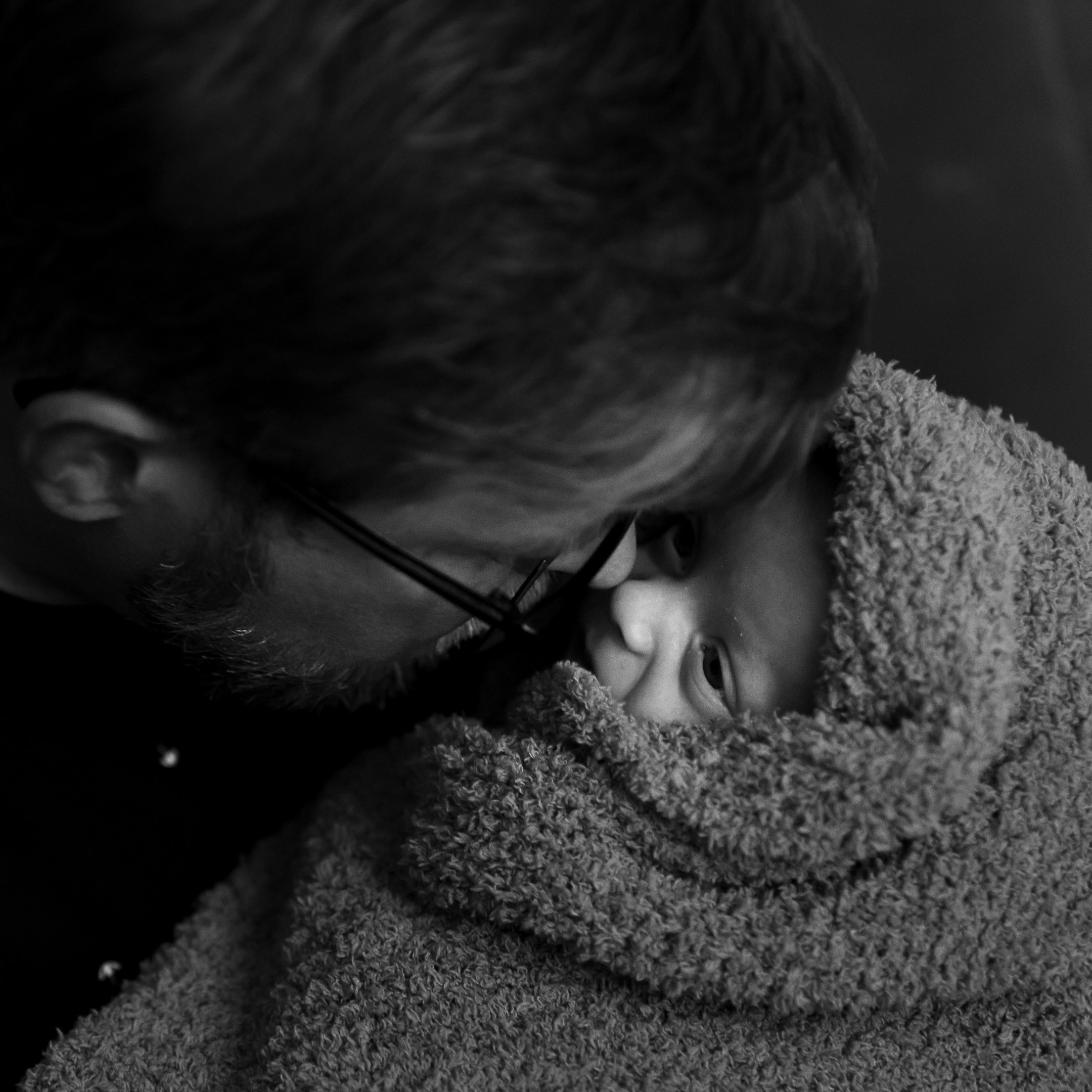 Newborn fotografie; papa knuffelt zijn kleine pasgeboren dochtertje