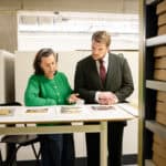 Minister van OCW Gouke Moes krijgt uitleg over het digitale CABR in het depot van de Groninger Archieven.